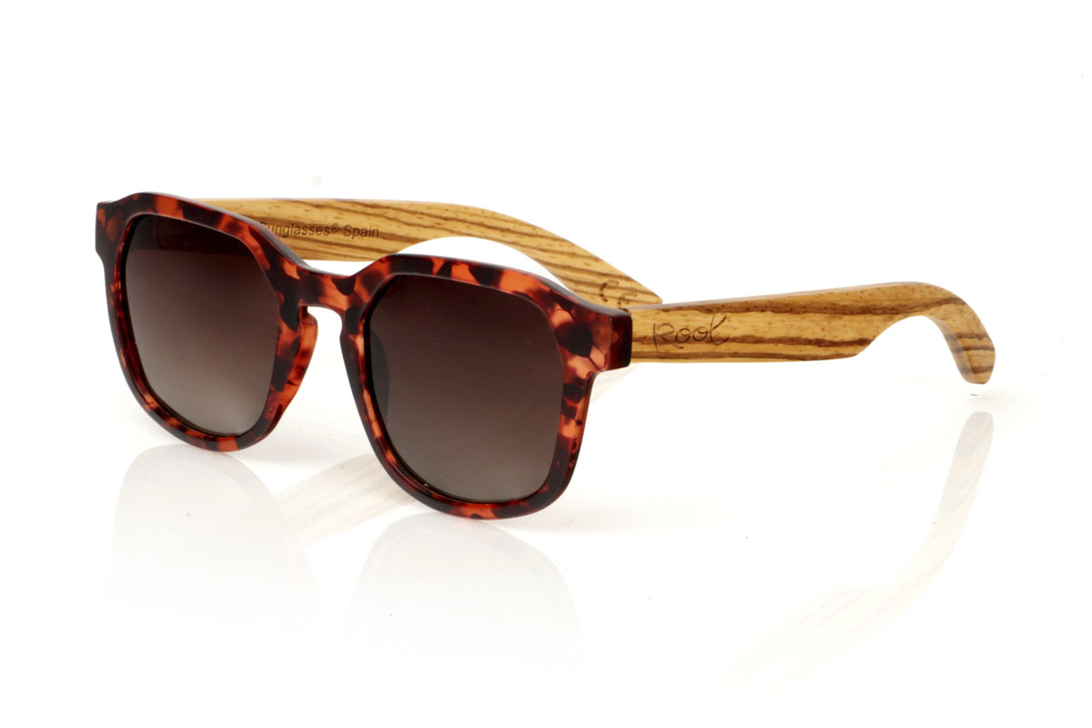 Gafas de Madera Natural de Zebrano MOON CAREY. Las MOON CAREY son todo lo que necesitas para darle un giro interesante a tu rutina. Con su montura color carey en tonos marrón y negro mate y la forma hexagonal, estas gafas capturan la esencia del estilo diario. Lo especial viene con las varillas de madera de Zebrano, cuyo veteado único asegura que no haya dos pares iguales. Cómodas, con protección total y perfectas para cualquier aventura bajo el sol. Son un básico con un toque extra. Dale a tu mirada ese algo especial. Medida frontal: 148x50mm. Calibre: 53.  Venta al Por Mayor y Detalle | Root Sunglasses® 